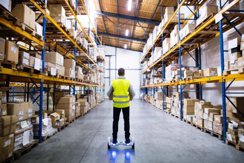 "Male warehouse worker using a hoverboard – Trusted wholesale supplier for Amazon FBA and retail businesses."