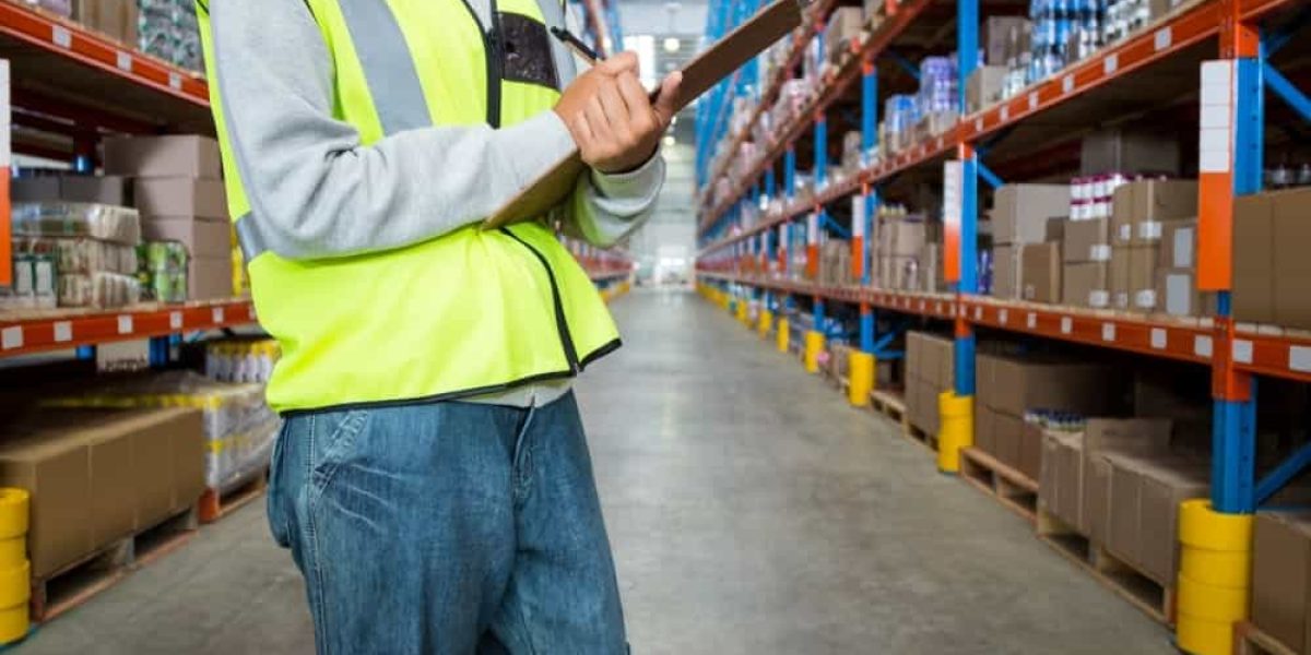 Female warehouse worker checking inventory at wholesale distributors in USA warehouse facility