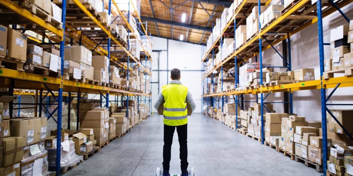 "Male warehouse worker using a hoverboard – Trusted UK wholesale supplier for Amazon FBA and retail businesses."